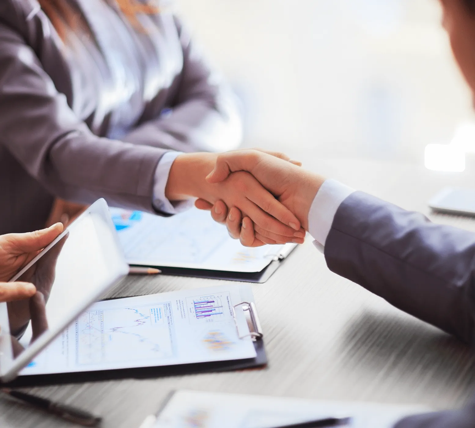 Two professionals shaking hands symbolizing partnership and collaboration with Retensa.
