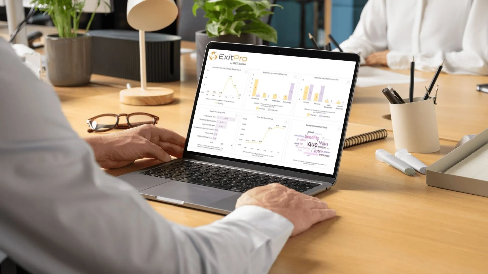 Person using ExitPro software with charts and graphs on laptop, symbolizing exit data analysis and reporting.