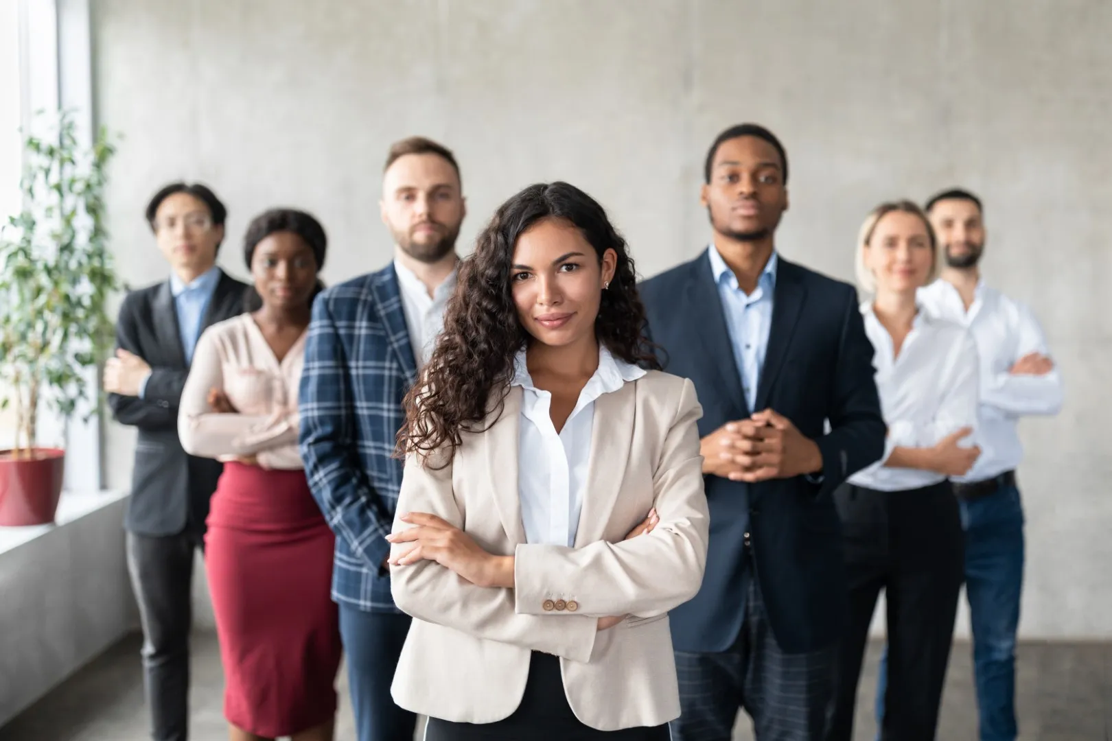 Professional team standing confidently in business attire inside a modern office, representing strong workforce retention and employer commitment.