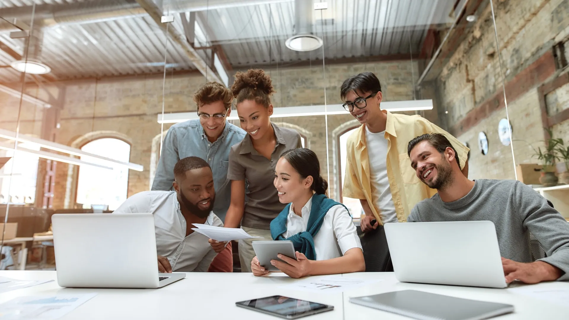 A team gathered around a table in a modern office, collaborating on a project, demonstrating teamwork and shared problem‑solving