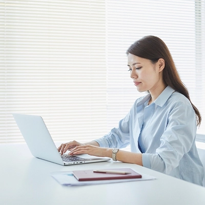 Woman working on a laptop at a desk in an office